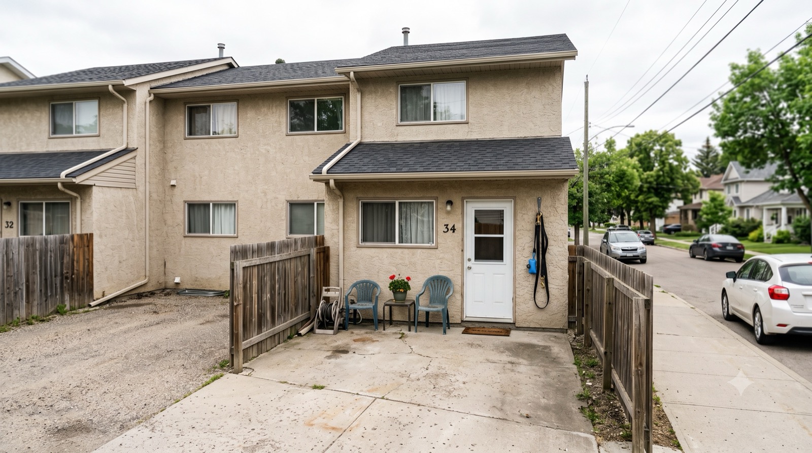 A duplex with a small concrete parking pad and no fenced yard, an ordinary home without private outdoor space